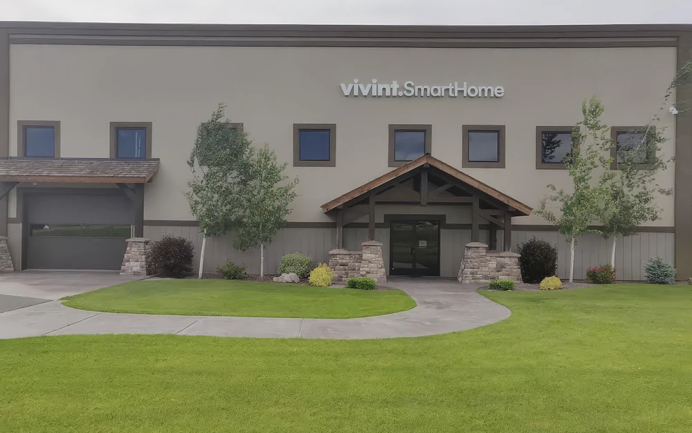 A completed office and warehouse building: a timber entry on stone piers, a lawn and a curved walk